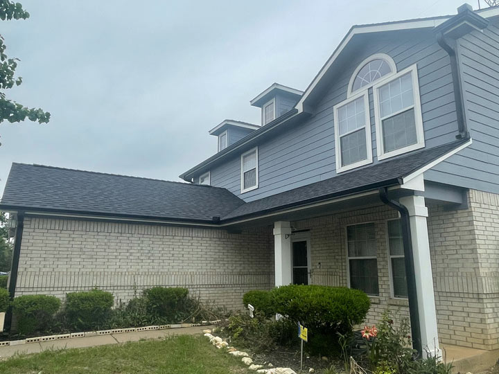 a two-story home with gutters and downspouts that are painted to match the roof exactly
