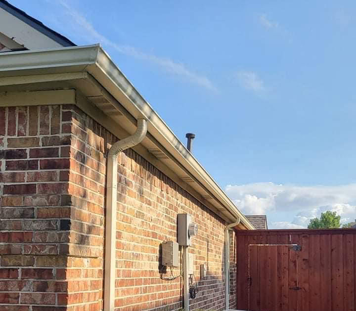 a gated residence with brick walls, gutters, and downspouts